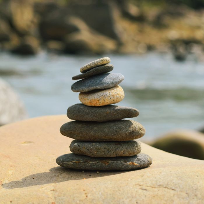 A serene stack of pebbles perfectly balanced on a rocky shore by the beach.